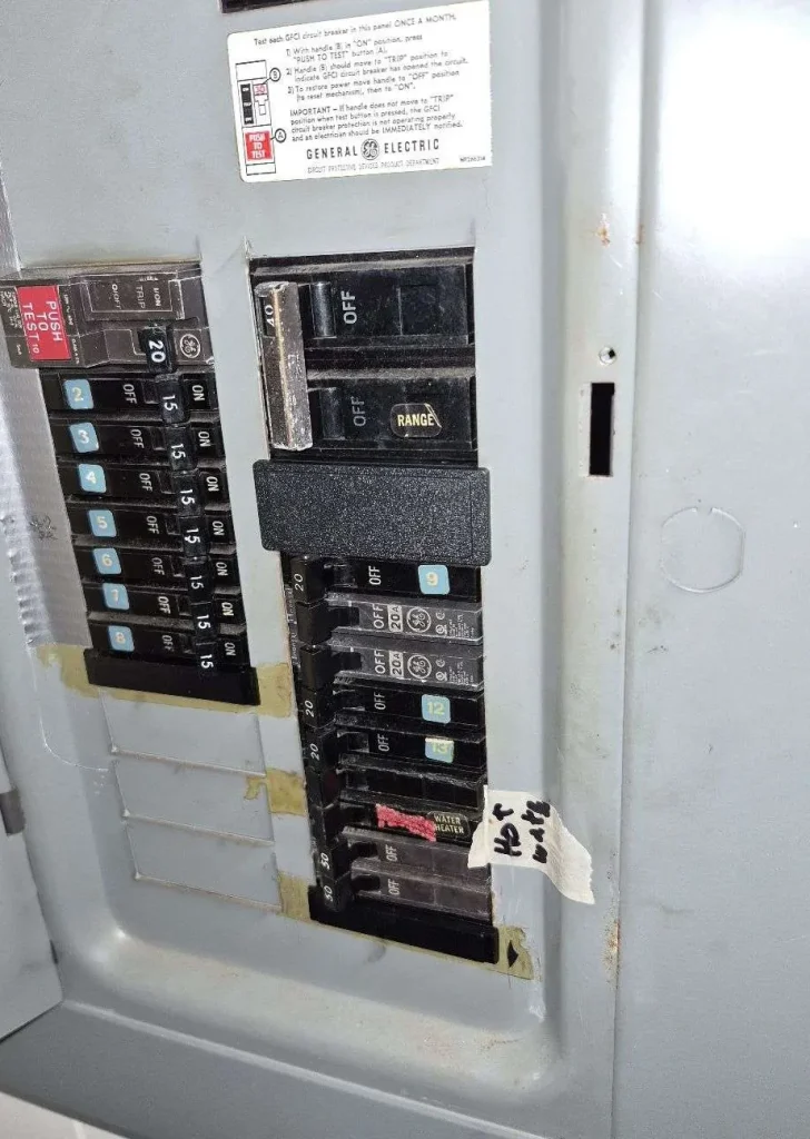 Older electrical panel with breakers opened up for inspection by a licensed electrician