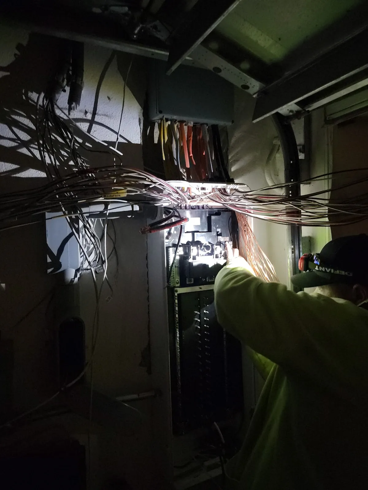 Electrical Repair & Troubleshooting Service Calls Electrician tracing circuits inside an open residential panel with a flashlight