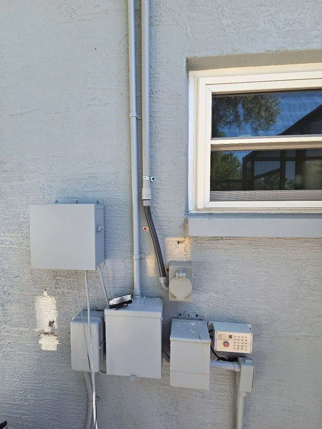 Exterior generator power inlet, transfer equipment and disconnects on a stucco wall in Lutz, FL