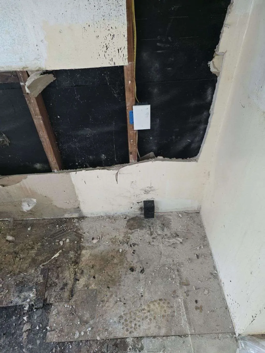 Fire-damaged wall section opened up with a new outlet box on the stud