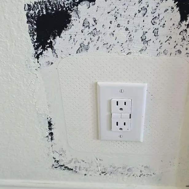 GFCI receptacle in a patched wall section awaiting paint