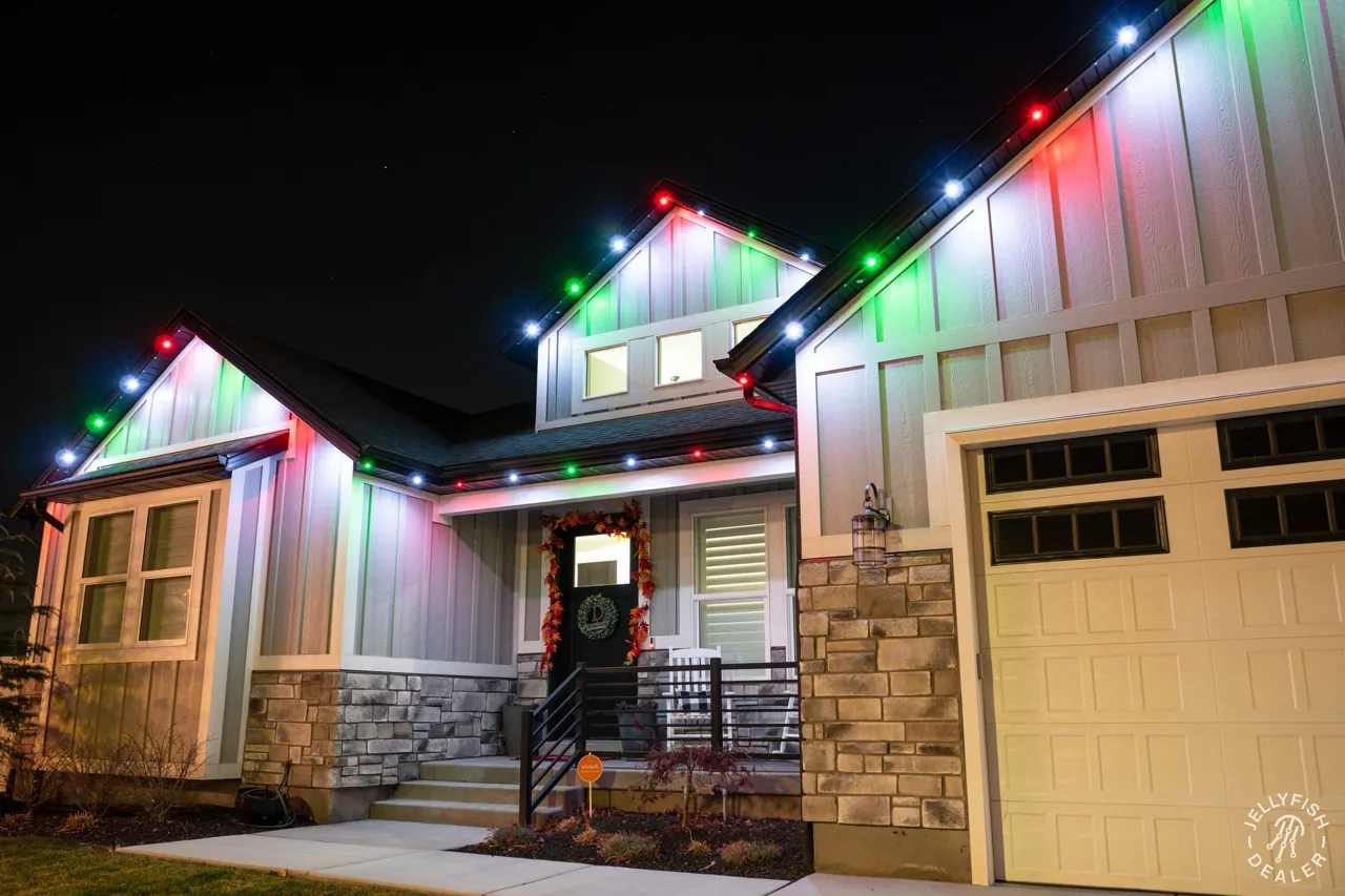 JellyFish permanent Christmas lights in red and green outlining a garage gable and porch