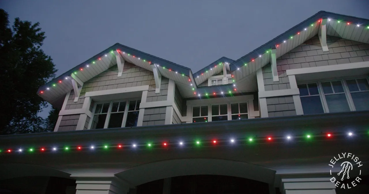 Permanent Christmas Lights in Clearwater Beach, FL Craftsman-style home at twilight with multicolor JellyFish permanent lights along the porch roof