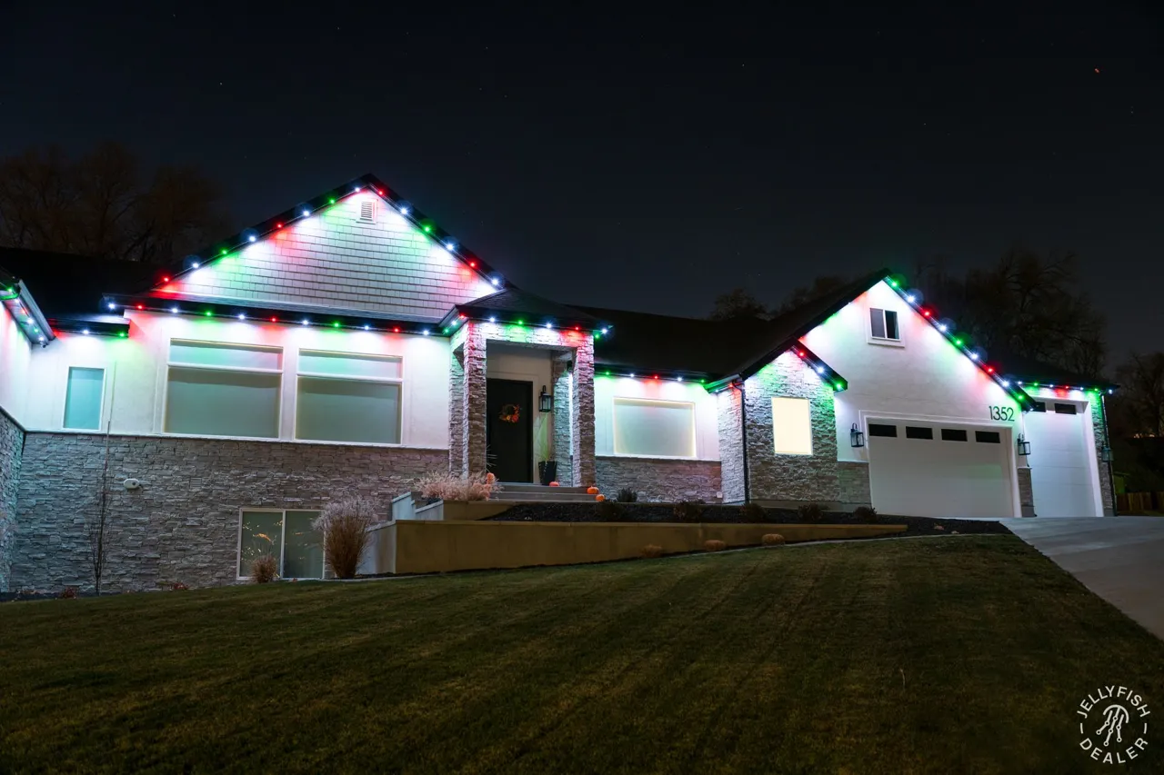 Single-story ranch home with multicolor JellyFish permanent lights along the eaves