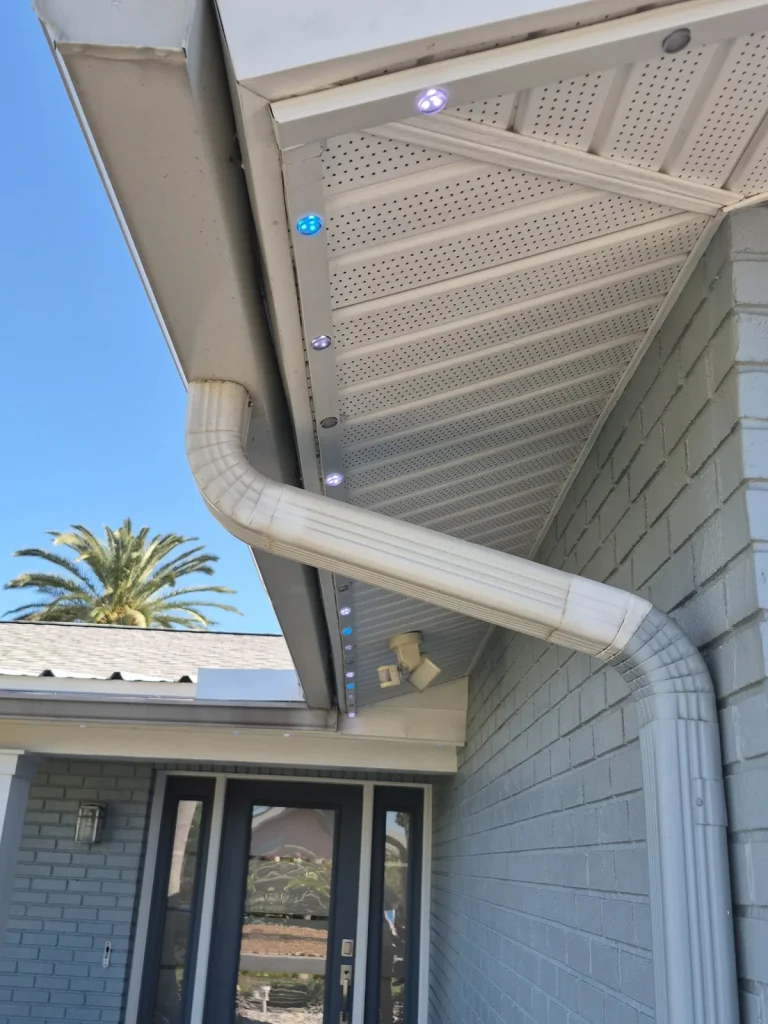 Booking Permanent Christmas Lights in Seminole: How Scheduling and Install Day Work JellyFish permanent lights tucked into the soffit beside a downspout on a Pinellas home in daylight