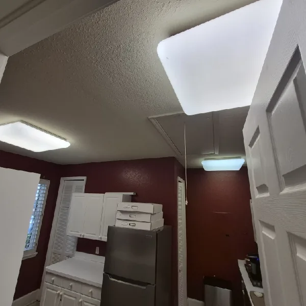 Commercial lighting remodel in St. Petersburg, FL – before: the kitchen with old flush-mount and fluorescent ceiling fixtures