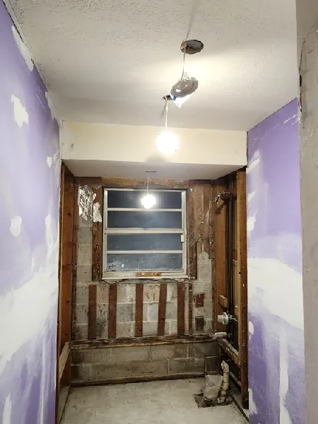 Recessed lighting installation in Pinellas Park, FL – before the hallway during the renovation, lit by one bare fixture