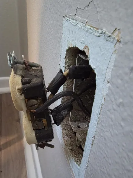 Old receptacle pulled from a damaged wall box during outlet troubleshooting in Seminole, FL