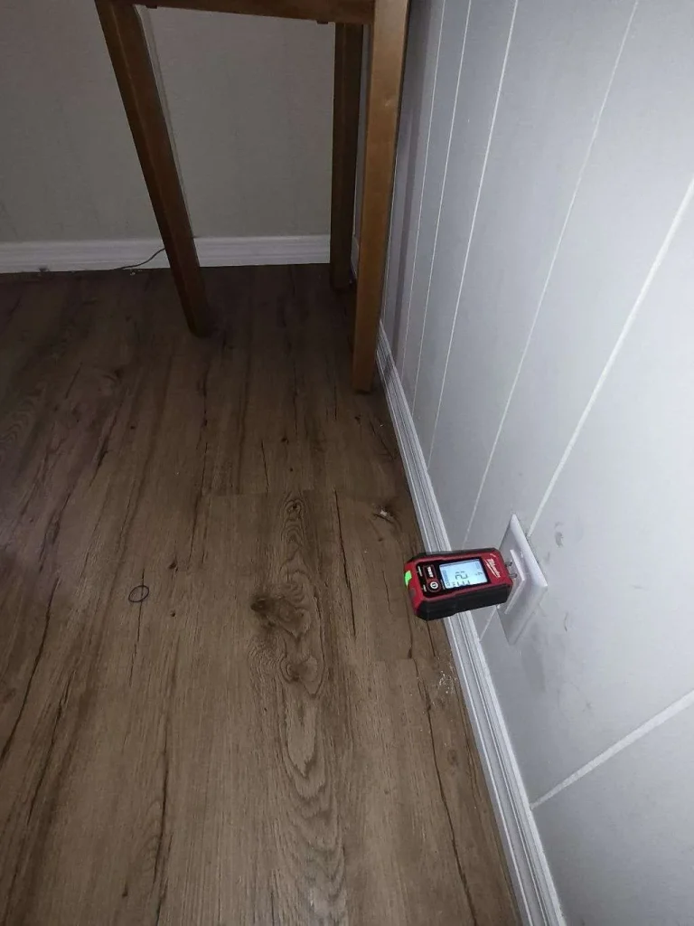 Member Care Plans Electrician testing a wall outlet with a receptacle tester during a home safety inspection