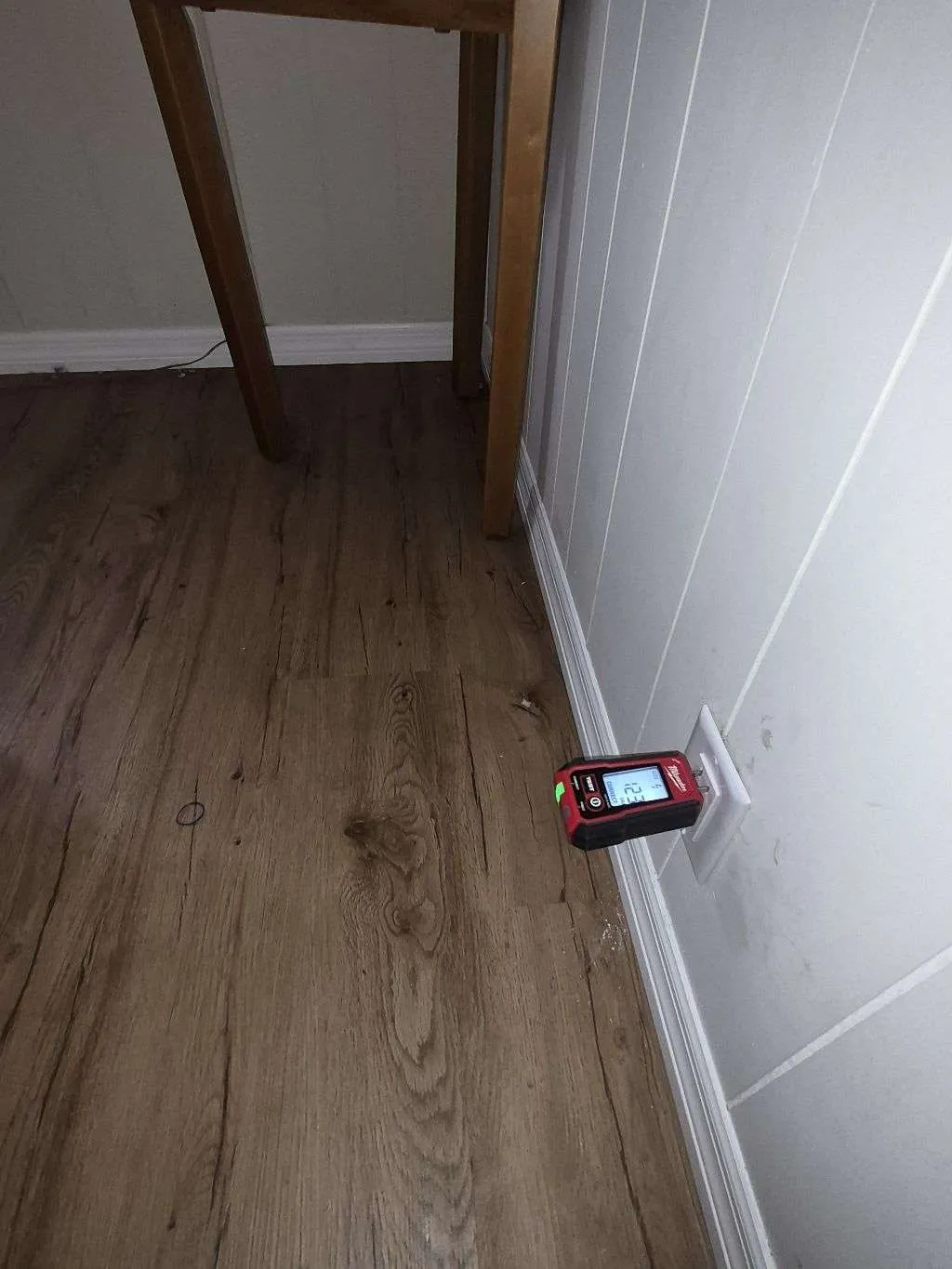 Electrician testing a wall outlet with a receptacle tester in a St. Petersburg home