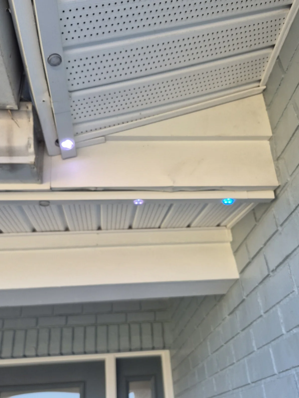 Permanent Christmas Lights in Seminole and Pinellas: A Local Guide to Year-Round Roofline Lighting Daytime close-up of permanent roofline light fixtures mounted along white fascia and soffit.